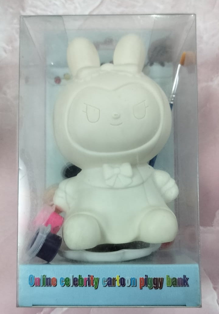 White cartoon-like piggy bank with a keychain in a clear packaging on a light pink background